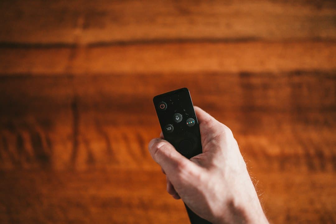 Hand met een afstandsbediening voor de tv, Hakuna IPTV en Hakuna TV